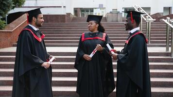 Multiracial diversity graduates in the mantles talking at university campus video