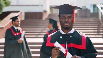 Young student on his graduation day in university campus standing with multiethnic group of friends video