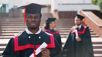 African american student on his graduation day in university campus standing with multiethnic group of friends video