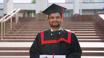 Portrait of Indian student with diploma near university video
