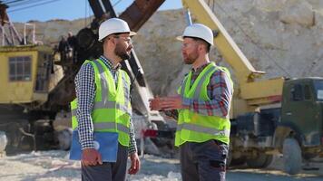 Two men engineers in uniform are talking at the stone quarry video