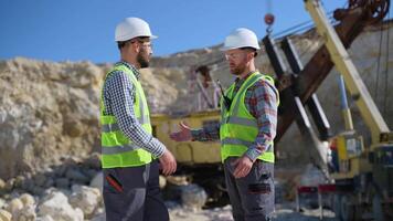 Two men workers are talking and shaking hands at quarry video