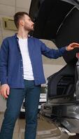 Customer choosing new car and checks it before purchasing in car dealership. Vertical video