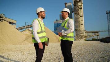 Two men engineers are talking and shaking hands at the stone quarry video