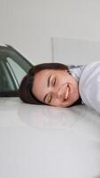 Happy woman hugging her new car. Vertical video