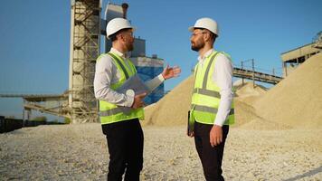 Two men engineers are talking and shaking hands at quarry video
