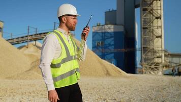Foreman instructing workers using walkie talkie radio set at quarry video
