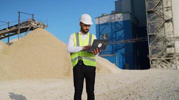 Engineer in hardhat use laptop to plan the work of a quarry video