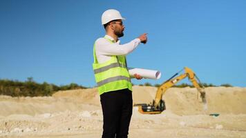 Foreman giving commands to employee in drilling machine using walkie talkie at quarry video