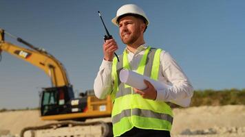 Engineer giving commands to employee in drilling machine using walkie talkie at quarry video