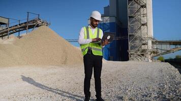 Engineer in hardhat use laptop to plan the work of a quarry video