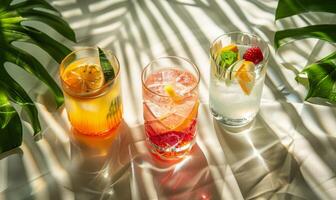 Three Refreshing Summer Cocktails With Fruit and Ice on White Fabric photo