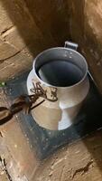 vertical bucket on a chain is lowered into a well of water. A bucket draws water video