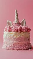 A delightful unicorn cake decorated with pink frosting and whimsical features on a pink background photo