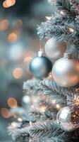 Decorative silver baubles on a Christmas tree with blurred lights in the background photo