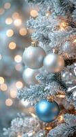 Decorative silver baubles on a Christmas tree with blurred lights in the background photo