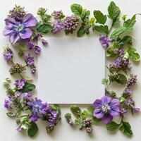 Hands holding a blank paper surrounded by lilac flowers on a light surface photo