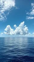 Clear blue water reflecting fluffy clouds over a calm ocean during a bright sunny day photo