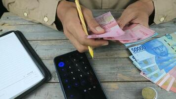 Close up hands counting Indonesian Rupiah banknote money video