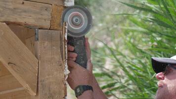 A man is using a power tool to cut wood. Concept of productivity and hard work. Slow motion video