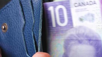 A closeup view of cash being stored in a blue wallet for financial purposes video
