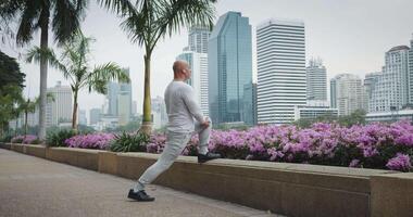 Man performs exercises during workout in park enjoying cityscape. Exercising in fresh air gives strength and energy. Combination of activity and unity with nature makes exercises especially effective. video