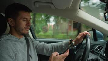 Driver using smartphone while driving car, distracted by messages on his phone. Dangerous driving of a vehicle, violation of traffic rules video