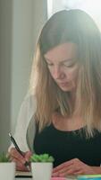 Person is sketching in notebook while working remotely at desk with laptop. Freelance work at home office. Graphic designer drawing sketch video