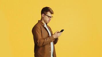 Man getting increasingly frustrated reading message on smartphone on yellow background video