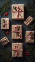Beautifully wrapped holiday gifts arranged with pinecones and candy canes on a dark background photo