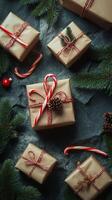 Beautifully wrapped holiday gifts arranged with pinecones and candy canes on a dark background photo