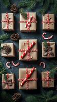 Beautifully wrapped holiday gifts arranged with pinecones and candy canes on a dark background photo