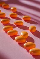 Bright orange circular candies arranged on a pink background photo