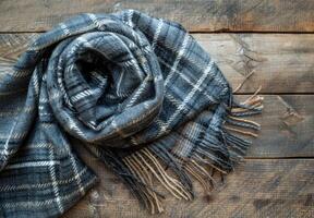 Black and Grey Plaid Scarf With Fringes on Rustic Wooden Background photo
