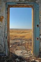 Open door framing a barren landscape under a clear blue sky photo
