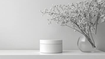A minimalist white round table with a cylindrical object and shadows in a serene indoor setting photo