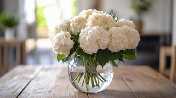 A lovely bouquet of white flowers in a jar on a rustic table at a sunset cafe photo