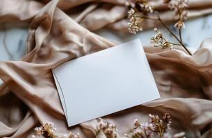 Blank White Card On Beige Fabric With Dried Flowers photo