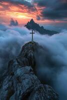 Dramatic mountain peak with a cross, surrounded by clouds and an expansive sky at sunrise photo