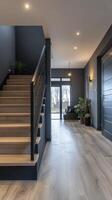 Stylish hallway with black walls, modern staircase, and natural accents near front door photo