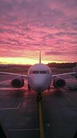 Sunset view of an airplane at the airport with vibrant skies in the background photo