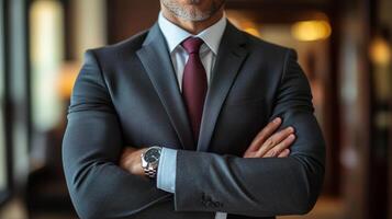 Business professional in formal attire with arms crossed in upscale office setting photo