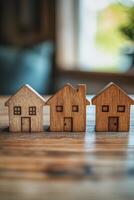 Collection of wooden house models displayed on a wooden surface in a neutral toned setting photo