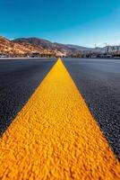 A long, empty street stretches into the distance, marked by a bright yellow center line photo