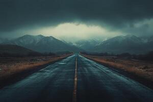 Dark and moody landscape with a winding road leading to distant mountains on a rainy day photo