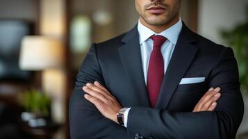 Stylishly dressed businessman stands confidently with arms crossed in a modern corporate setting photo