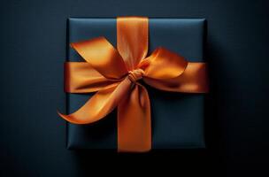Elegant black gift box with orange ribbon on a dark background suitable for various celebrations photo