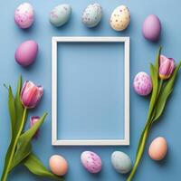 Colorful Easter eggs arranged with flowers around a blank picture frame on a purple background photo