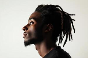 Profile of a young man with dreadlocks gazing upwards against a soft background photo