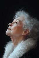 Elderly woman gazing thoughtfully with grey hair and a fur collar in soft light photo